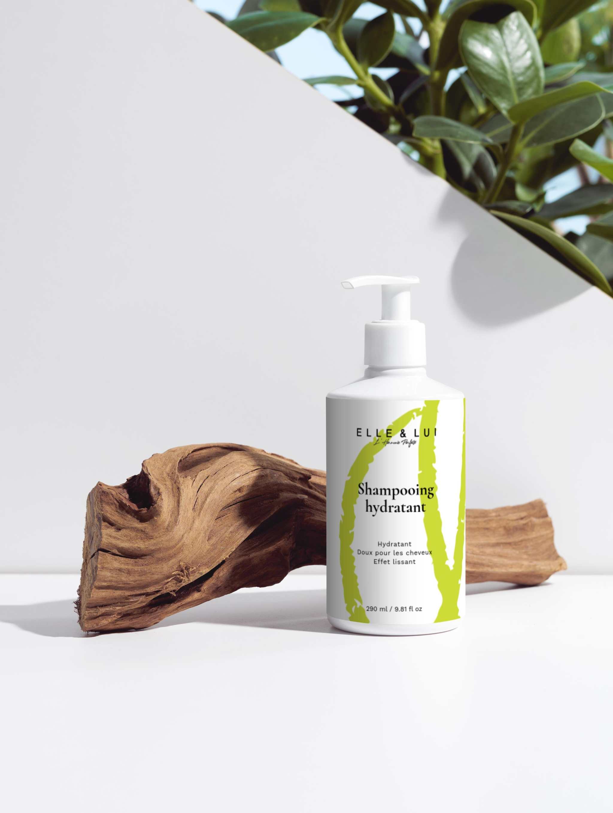 Flacon de shampooing hydratant sur fond clair avec déco bois et plantes, soin pour cheveux doux et éclatants
