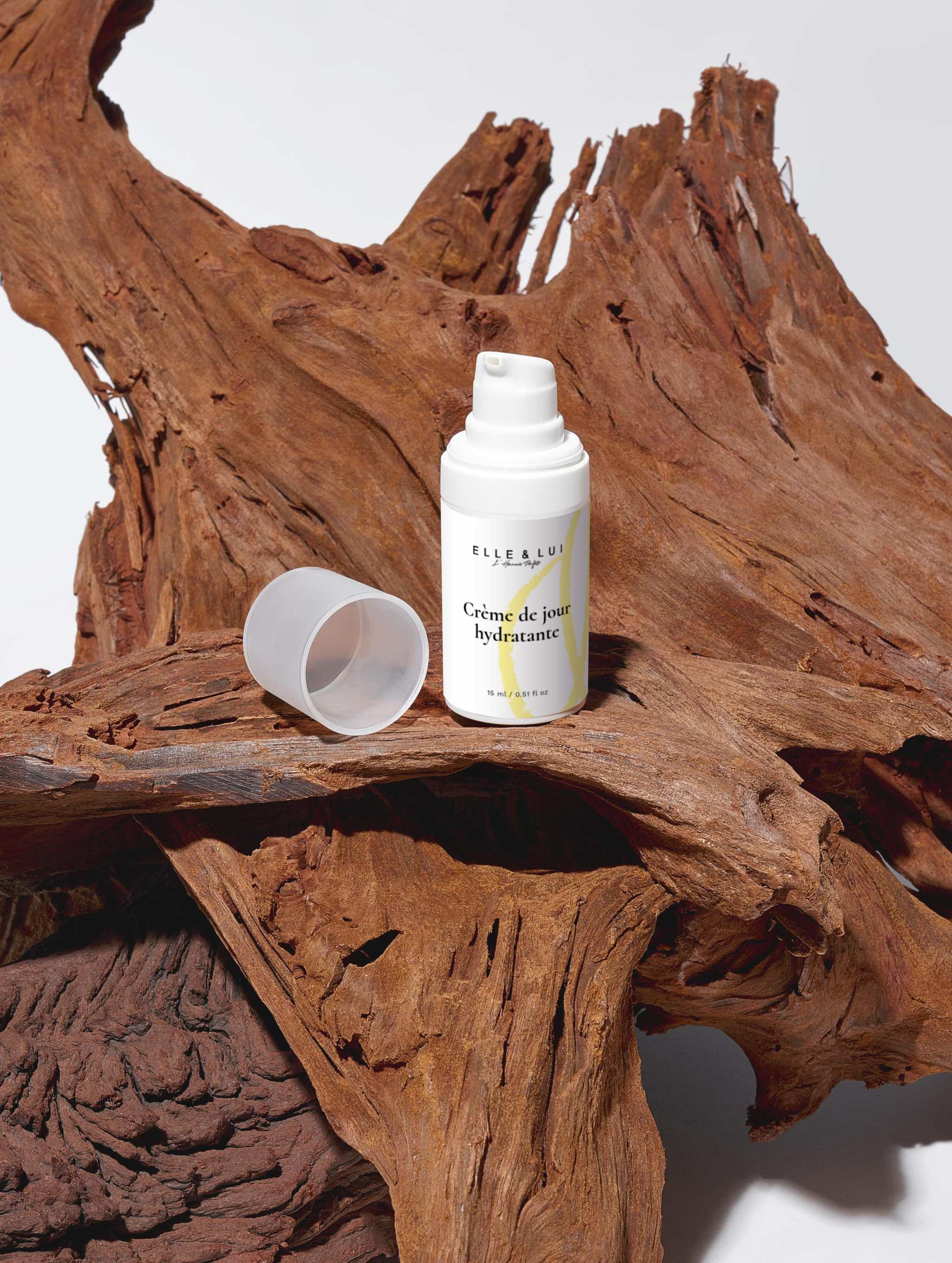 Crème de jour hydratante de la boîte de collection de soins solaires SPF50 posée sur bois séché naturel.
